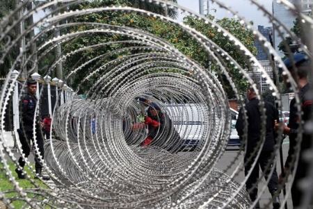 کشیدن سیم خاردار در مقابل پارلمان اندونزی در شهر جاکارتا برای ممانعت از نزدیک شدن معترضان به ساختمان پارلمان/ EPA عکسهای جالب,عکسهای جذاب,سیم خاردار