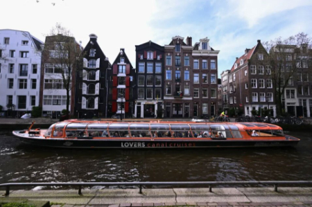 عکسهای جالب,عکسهای جذاب,قایق گردشگری در حال عبور از کانالی در شهر آمستردام هلند