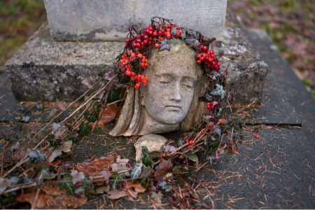 عکسهای جالب,عکسهای جذاب,سر یک مجسمه آسیب‌دیده، روی سنگ قبری در گورستان 