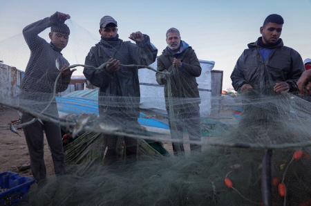 عکسهای جالب,عکسهای جذاب,ماهیگیران در حال باز کردن تور در ساحل نوار غزه